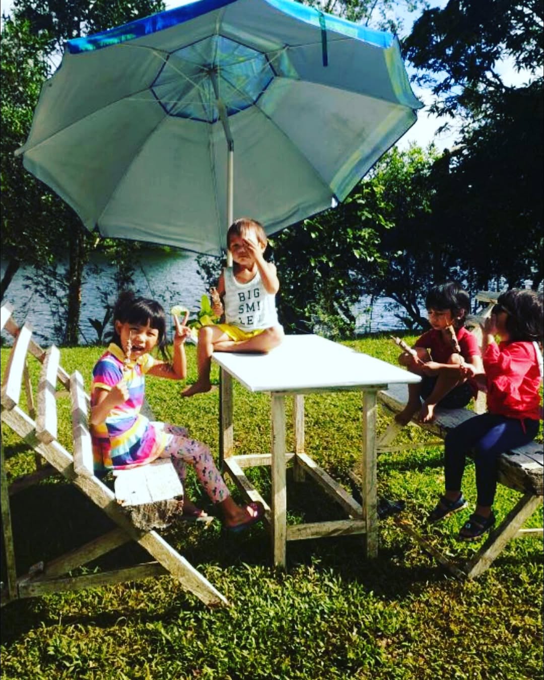 Kids enjoying at the lakeside table with umbrella outside the Triangle Tent area