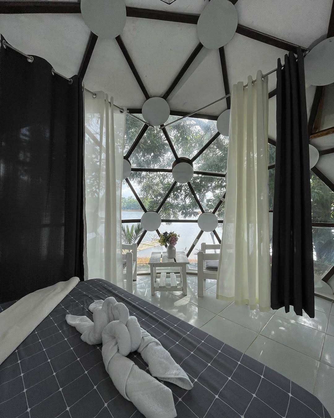 Dome BalaGhee interior — double bed with lake view through geodesic panels